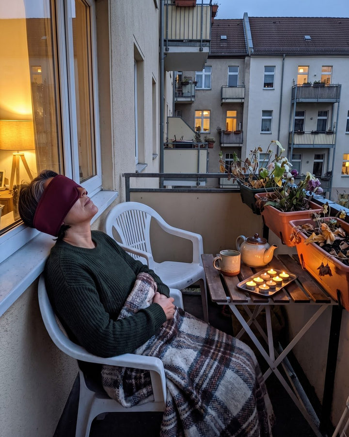Frau sitzt mit der Kühlmaske auf dem Balkon